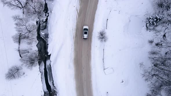 Aerial View of the Car Moving Forward By Snowed Road