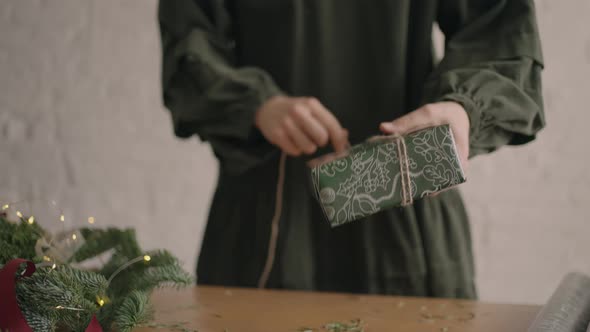 Closeup Girl Wraps Up a Gift and Ties It with a Rope