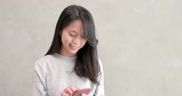 Woman use of mobile phone over grey background