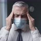 Businessman with face mask massaging his temples - VideoHive Item for Sale