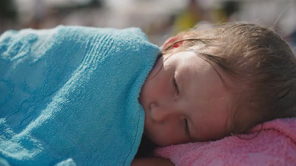 Cute Little Child Awakes Napping on Deck Chair on Beach