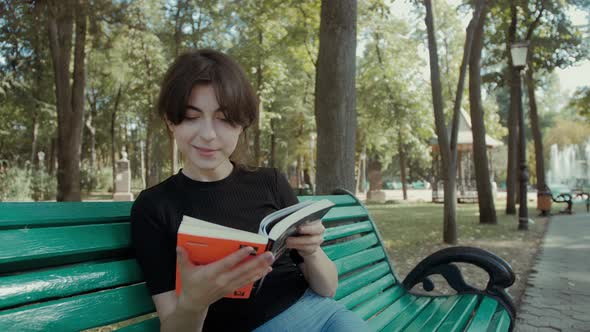 Young woman reading a book on a park