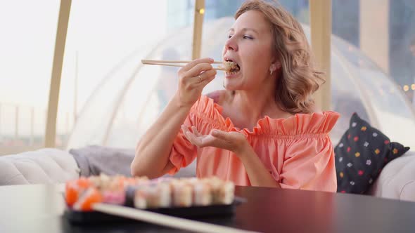 an Attractive Woman Eats Rolls with Sticks