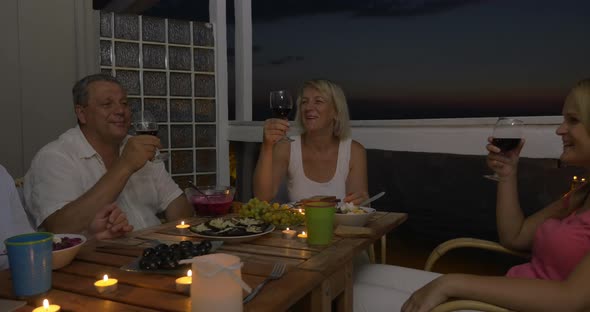 People enjoying food and wine during home dinner