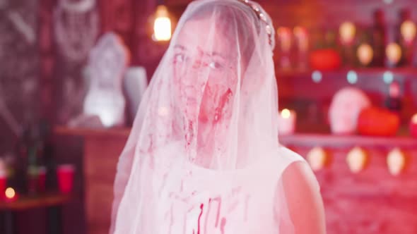 Portrait of a Young Girl with a Bloody Bride Veil on Her Face As a Halloween Costume