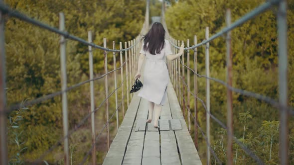 Woman in a Beautiful Dress, Runing on a Bridge in Woods