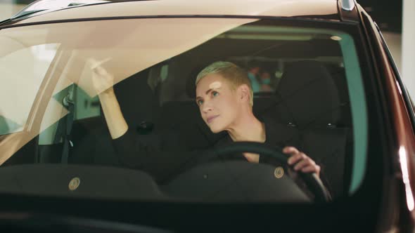 Beautiful Female Customer of Showroom Testing Interior of New Auto While Sitting