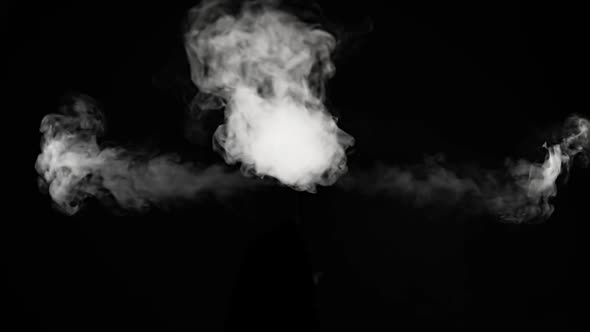 Smoke shoots to the left and right and billows out towards the camera from the center.