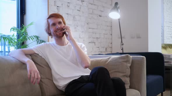 Redhead Designer Talking on Phone Sitting on Couch