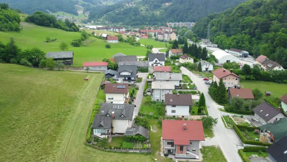 Flying up in front of small settlement of family houses between beautiful green nature. Aerial 4k vi