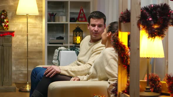 Romantic Young Couple Sitting on the Couch on Christmas Day