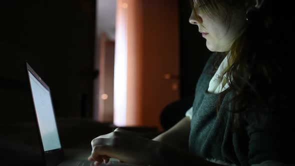 Young beautiful woman at home using notebook at night