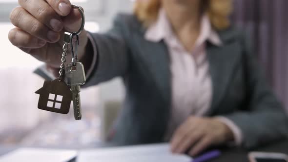 Woman in Formal Suit Showing Home Keys To Camera