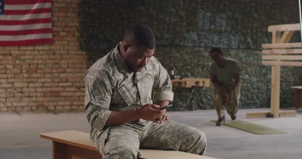 Black Military Men Using Smartphone in Gym Together