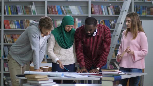 Multi Ethnic Students Discussing Layout of Project