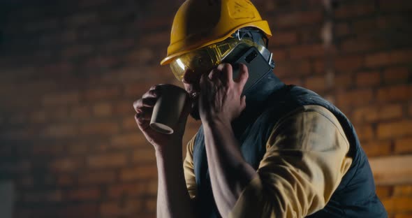 Male Builder Speaking on Smartphone During Lunch Break