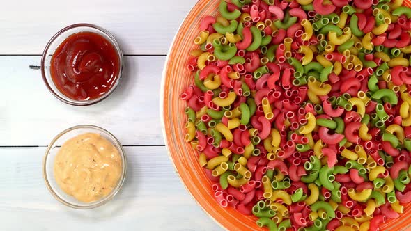 Multicolored Uncooked Raw Italian Pipe Pasta Rotating Slowly on Turntable in Dish