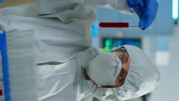 Vertical Video Neurologist with Ppe Suit Working at Vaccine Development Analysing Blood Sample