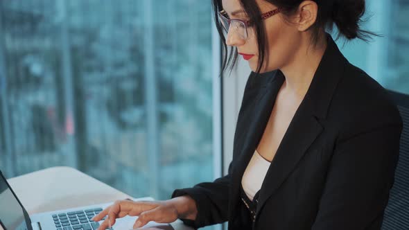 Portrait of a Young Woman Working at a Computer in a Modern Office