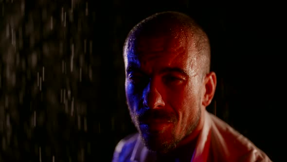 Portrait of Middleaged Man in Rain on Street in Night Closeup of Face in Dramatic Lights