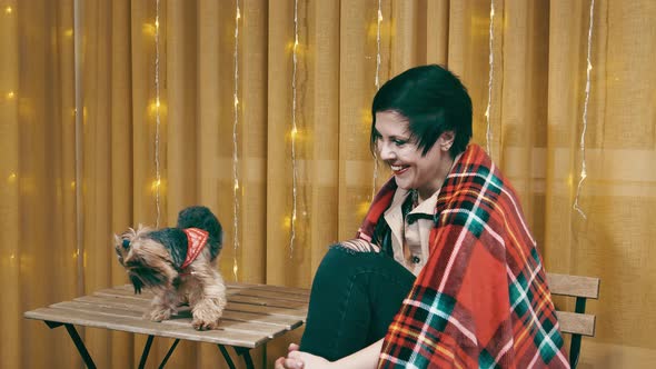 A Dog Walking on the Table and a Woman Rejoicing and Smiling at Her Pet