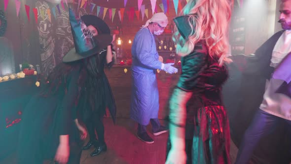 Enchantress in Black Sensual Outfit Dancing with Her Scary Friends at a Halloween Party