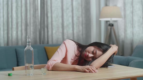 Drunk Asian Woman With Smartphone On Table Drinking Vodka And Sleeping At Home