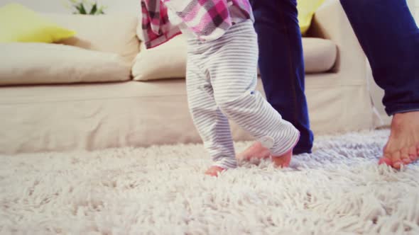 Dad assisting baby to walk