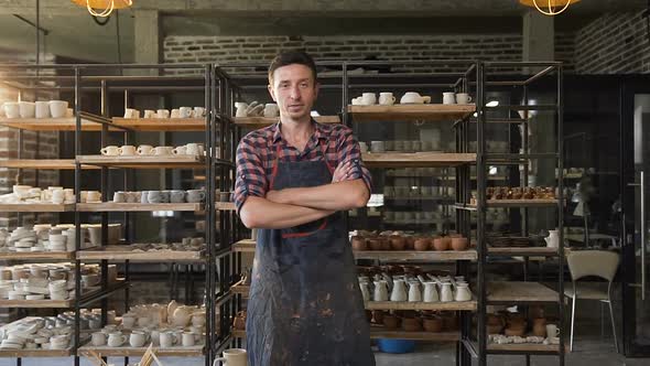 Attractive Male Potter Crossing Hands and Looking to Camera in the Pottery