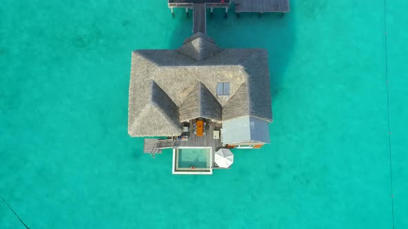 Aerial drone view of a luxury resort and overwater bungalows in Bora Bora tropical island.