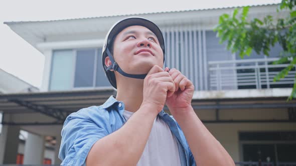 Asian active sportsman wear protective sport helmet before ride Surf Skate Board for exercise.