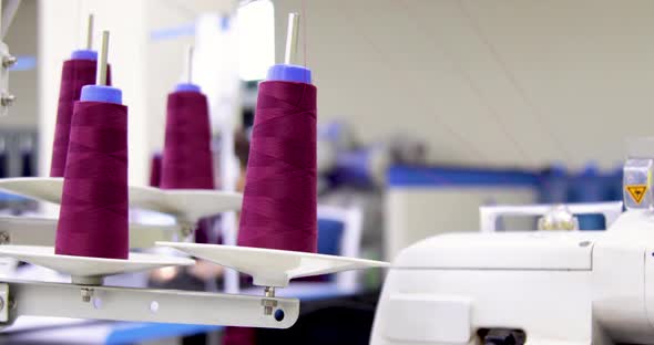 Purple spool of sewing threads unrolling on sewing machine