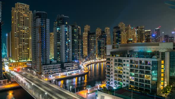 Dubai Marina at Night Timelapse with Light Trails of Boats on the Water and Cars Dubai UAE