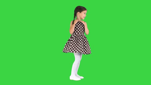 Smiling Little Girl Posing and Twirling Her Polka Dot Dress on a Green Screen Chroma Key