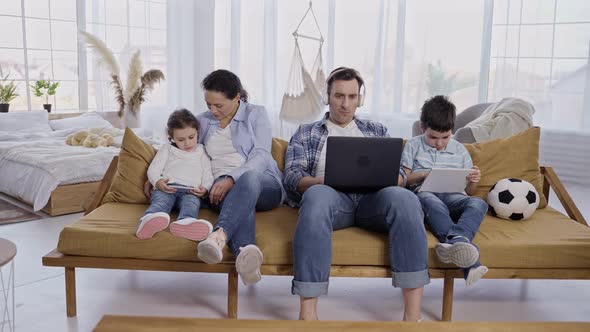 Modern Family with Children Using Gadgets at Home