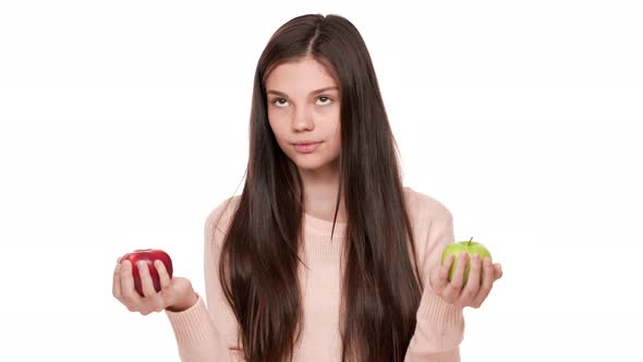 Portrait of Reflecting Woman 20s Hesitating Red or Green Apple to Eat Making Decision Eating Red