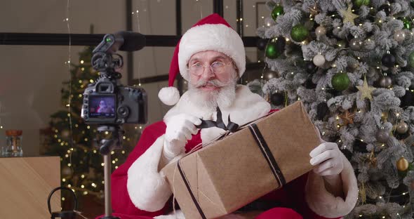 Santa Claus Recording Video Appeal to Kids Taking Orders for Christmas Gifts Sitting in Front of