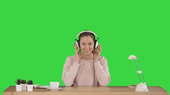 Young smiling woman putting headphones on and listening