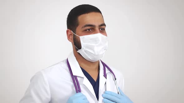 Arab young doctor in medical mask smiling at camera. The end of the coronavirus pandemic