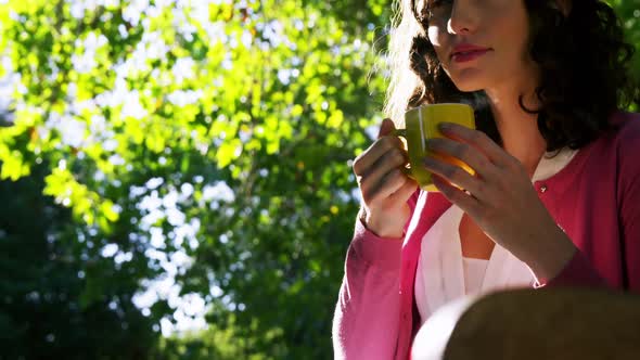 Beautiful woman drinking coffee in garden