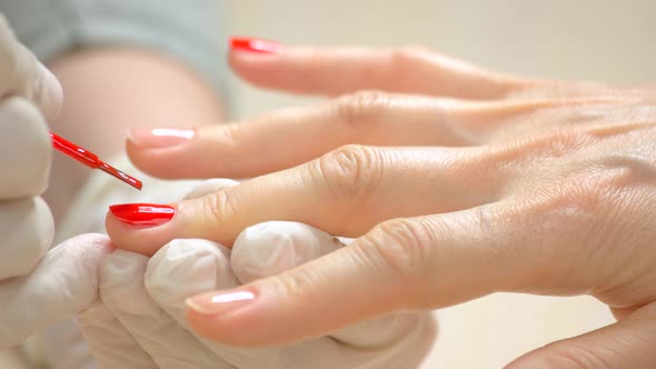 Manicurist Applying Red Varnish on Nails.