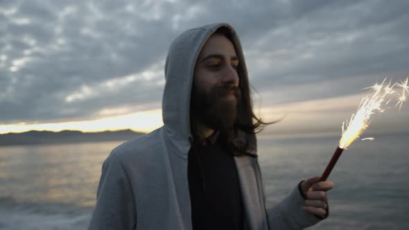 Young hipster guy holding a lit party candle in his hand