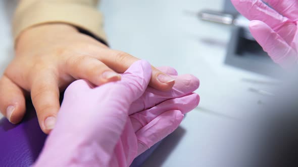 Beautician Hands Clean Nails Carefully with Manicure Tool