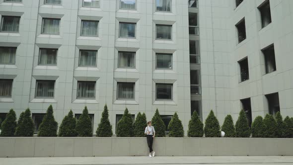 Man Looking to Camera While Standing Outdoors Business Building on the Background Slow Motion