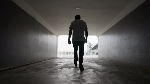 Man Walks an Underground Passage Into the Light From the Darkness