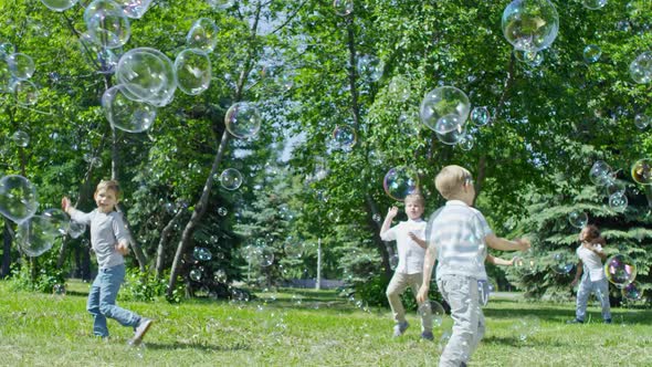 Adorable Kids Bursting Huge Bubbles in Park alt