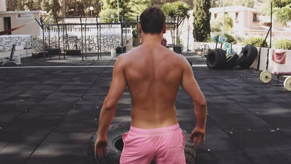 Young Man Exercising Outdoors Doing the Barbell Back Squat