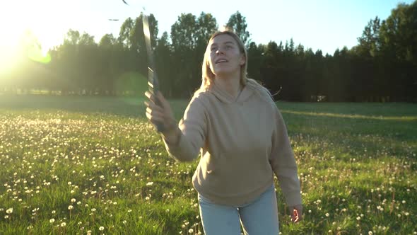 Young Woman Playing Badminton Active Games in Summer in Nature