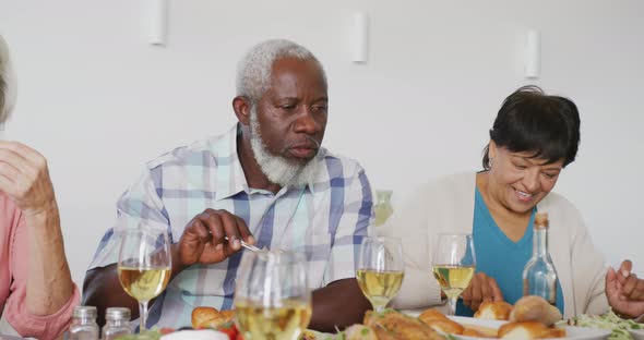 Happy senior diverse people having dinner at retirement home