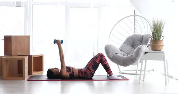 Strong fitness black woman doing arm workout with dumbbells.